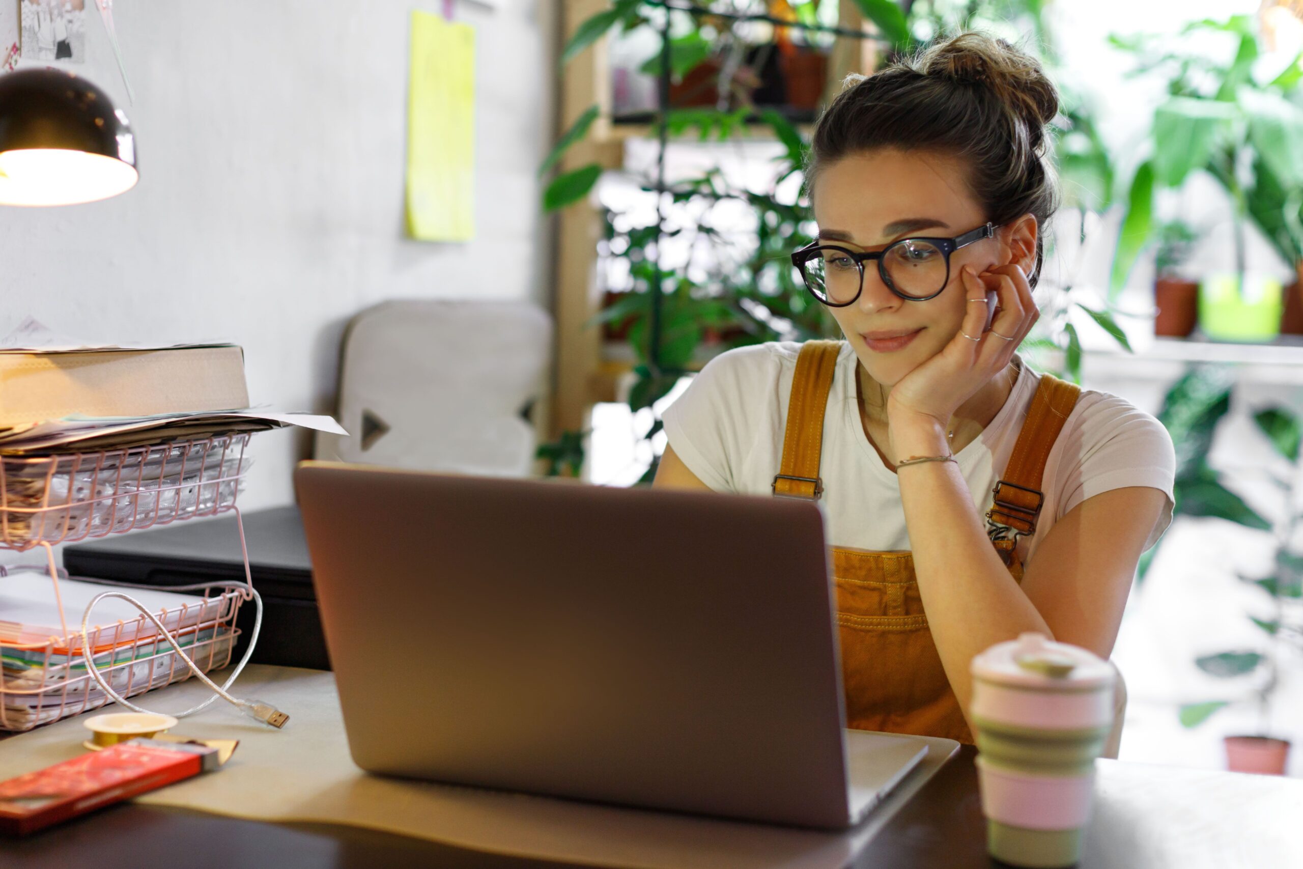 Young adult at desk with a laptop